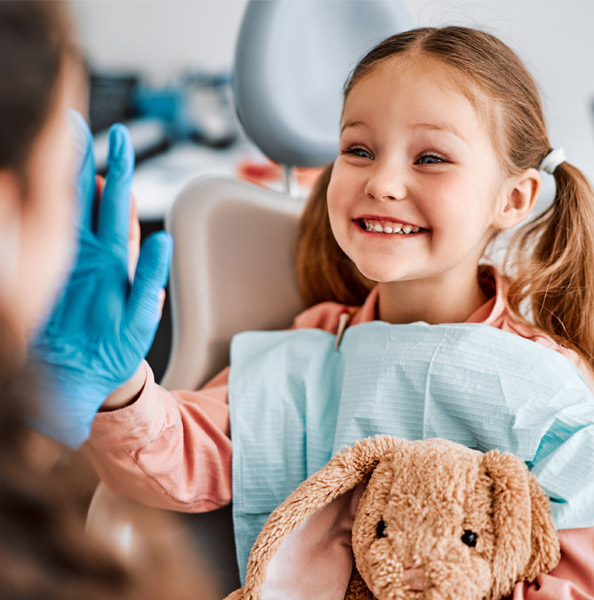 Young girl giving a high-5 with the dentist in Idaho Falls.