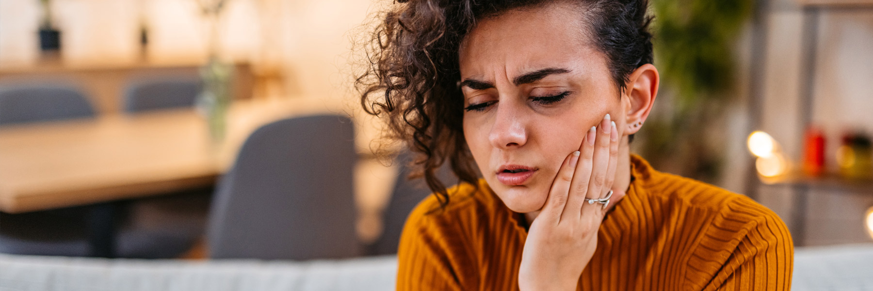 Woman with toothache emergency prepping to call her dentist in Idaho Falls, Dr. Michael Elison.