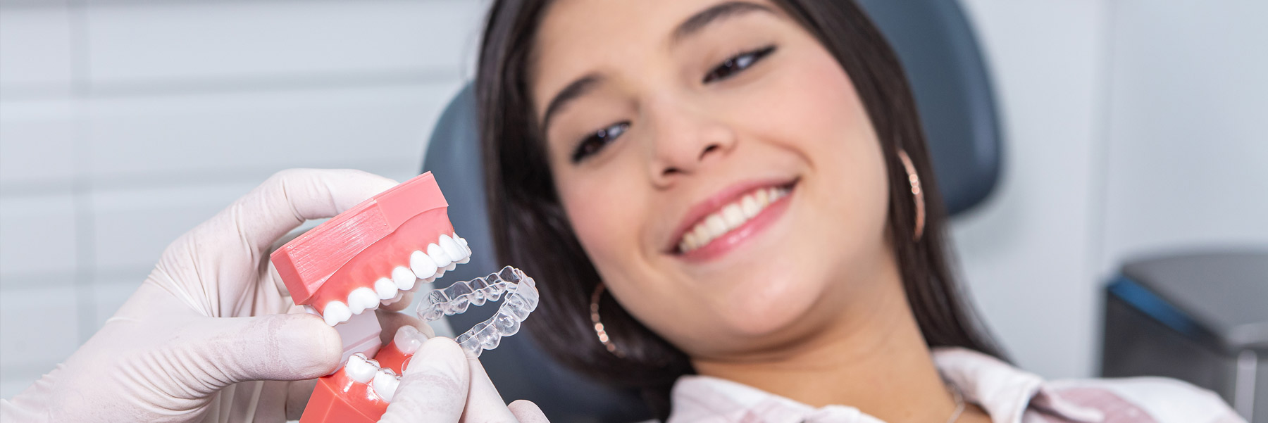 Woman with a big smile receiving whitening trays from her dentist in Idaho Falls, Dr. Michael Elison.