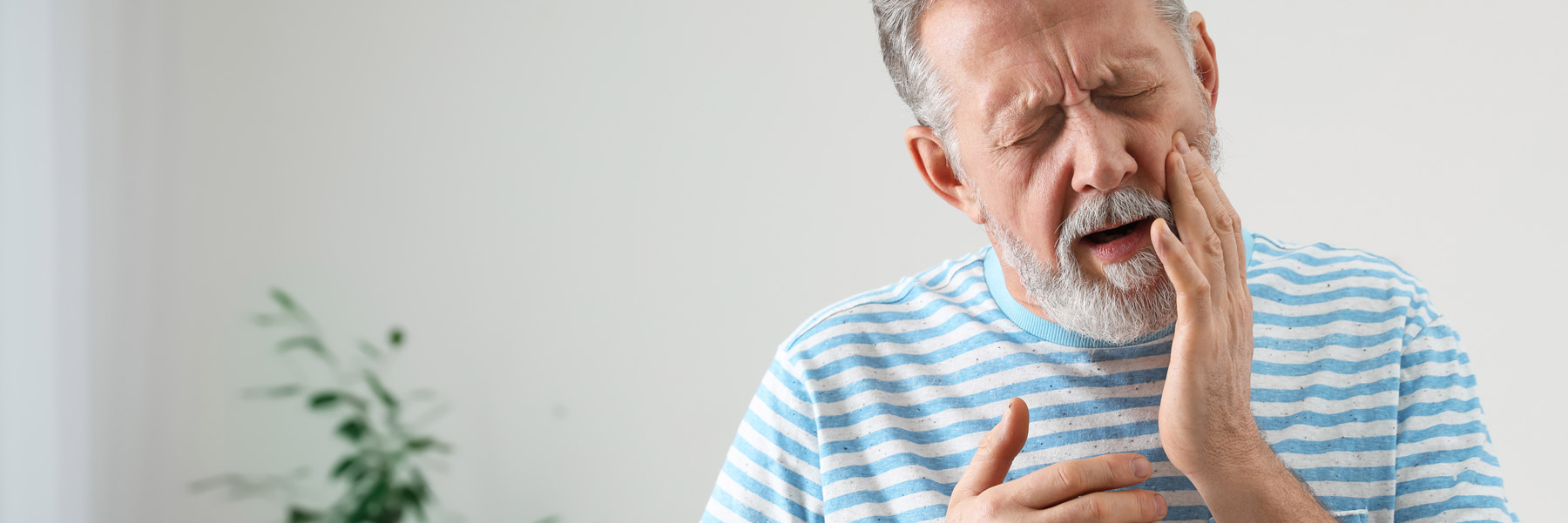 Man with a toothache needing a tooth extraction from his family dentist in Idaho Falls, Dr. Michael Elison.