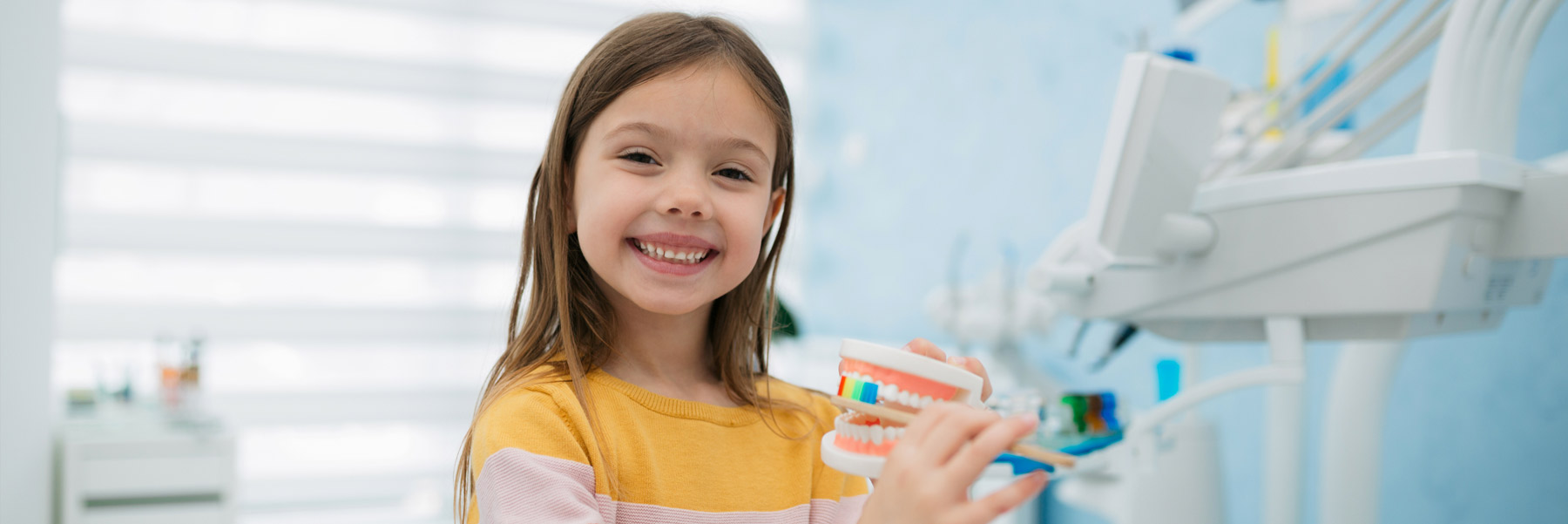 Young girl brushing teeth model at her dentist in Idaho Falls at Elison Dental Center.