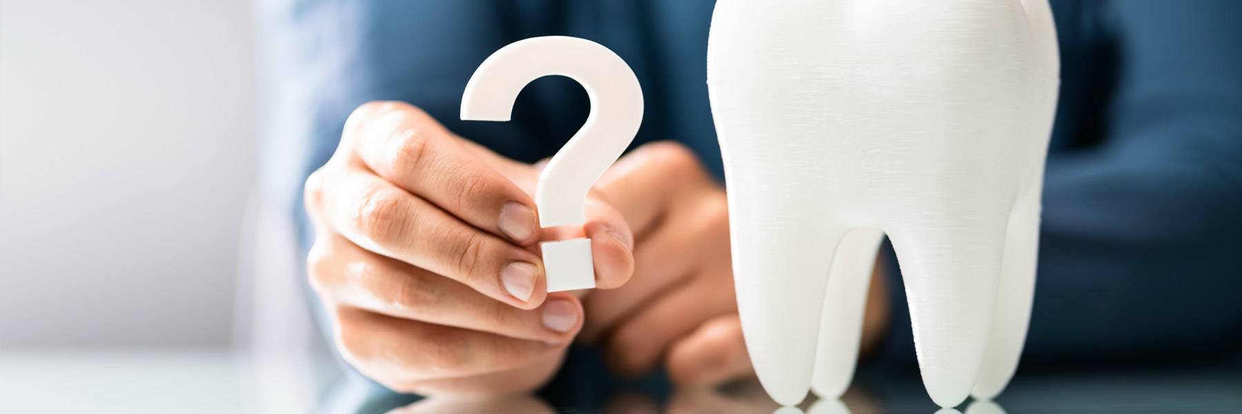 Woman holding a question mark next to a tooth symbolizing asking their dentist in Idaho Falls, Dr. Michael Elison a question.