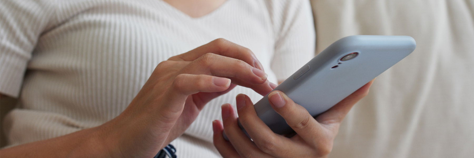 Woman using cell phone to contact your dentist in Idaho Falls, Dr. Michael Elison.