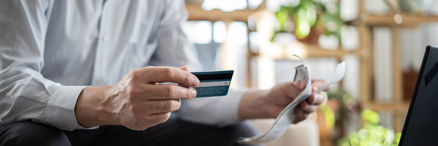 Person holding a credit card preparing to make a payment to the dentist in Idaho Falls, Elison Dental Center.